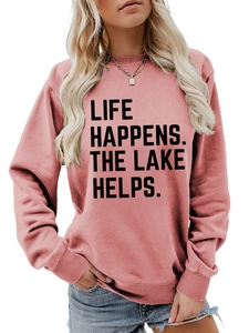 Detail showing the 'LIFE HAPPENS. THE LAKE HELPS.' print on a pink crewneck sweatshirt