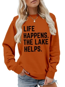 Detail of caramel orange sweatshirt featuring bold Life Happens The Lake Helps text print