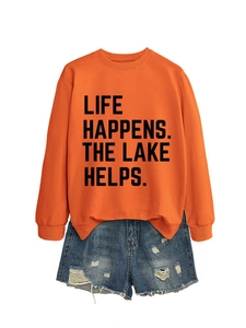 Detail of the Life Happens lettering print on a bright orange long sleeve sweatshirt