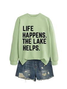 Detail of light green sweatshirt with Life Happens letter print and distressed denim shorts