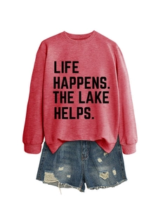 Flat lay of a red sweatshirt with 'LIFE HAPPENS THE LAKE HELPS' text and denim shorts