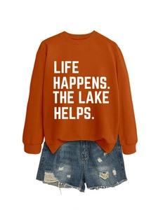 Detail of orange sweatshirt with LIFE HAPPENS print and distressed denim shorts