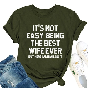 Détail d'un t-shirt vert armée avec lettrage blanc et ourlet noué à la mode au bas