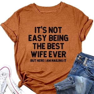 Détail d'un t-shirt caramel avec le message It's Not Easy Being The Best Wife imprimé