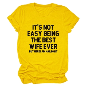 Détail des manches retroussées et du slogan noir sur un t-shirt en coton jaune