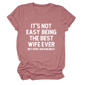 Détail d'un t-shirt en coton rose poudré avec slogan vintage blanc et col rond classique