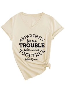 Close-up of beige V-neck t-shirt with front print and decorative knot at the hem