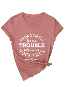 Detail of Dusty Rose V-neck T-shirt featuring side-knot hem and white graphic slogan