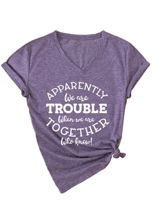 Detail of purple V-neck T-shirt showing white graphic print and stylish knotted hem