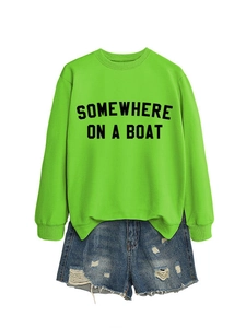 Flat lay di felpa verde neon con testo nero e pantaloncini di jeans blu strappati