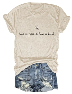 T-shirt beige 'love is patient' avec mini-short en jean effiloché sur fond blanc épuré