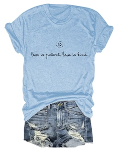 Détail de l'imprimé 'love is patient' avec petit cœur sur t-shirt bleu clair