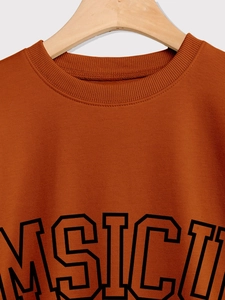 Detail of a brown orange sweatshirt featuring ribbed crew neck and MSICI college print