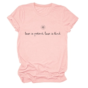 Détail de la manche retroussée et imprimé Love is Patient noir sur T-shirt rose pastel