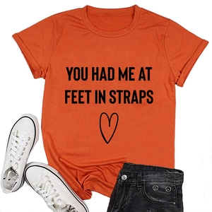 Detail eines orangefarbenen Baumwoll-T-Shirts mit dem Spruch You Had Me At Feet und Herz
