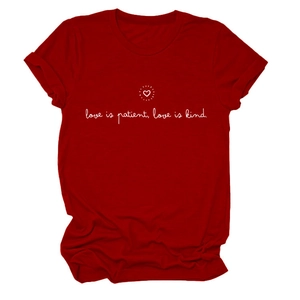 Détail du t-shirt rouge à col rond avec slogan blanc Love Is Patient et icône cœur