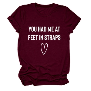Detail eines burgunderroten T-Shirts mit YOU HAD ME AT FEET Aufdruck und Herzgrafik