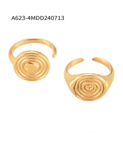 Close-up of gold-plated stainless steel rings with heart relief and spiral texture