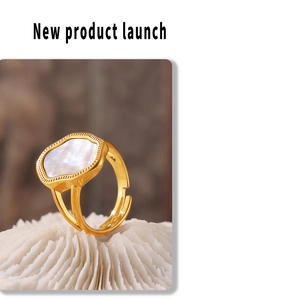 Vista macro di anello regolabile placcato oro 18k con conchiglia bianca e bordo ondulato