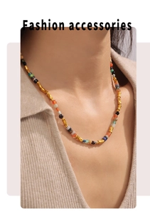 Détails de perles colorées et d'entretoises dorées en forme de bambou sur un collier boho