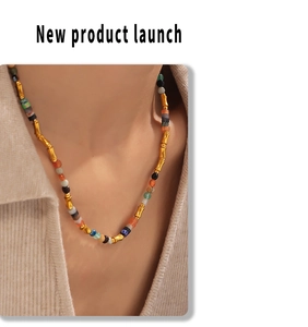 Gros plan d'un collier bohème en perles de pierre naturelle avec entretoises en bambou doré