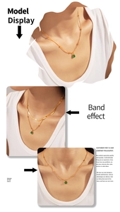 Détail du collier français en perles dorées avec un pendentif en pierre de verre verte