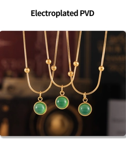 Détail de colliers en PVD or avec pendentifs en pierre verte et billes dorées