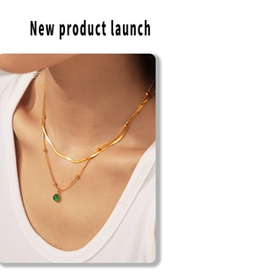 Gros plan du collier superposé plaqué or 18k avec pendentif en pierre verte sur modèle