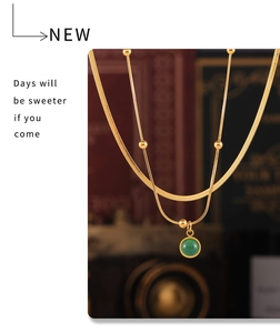 Détail d'une chaîne serpent plaquée or 18k avec pendentif rond en pierre verte