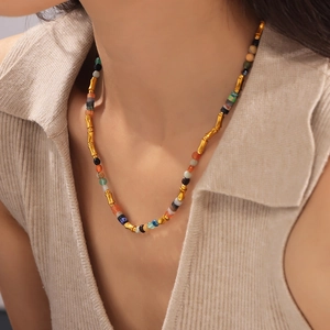 Collier bohème en pierres naturelles colorées avec accents métalliques dorés sur modèle