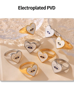 Detailed PVD plated gold and silver heart rings with evil eye motif on fabric