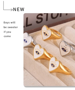 Detail of 18k gold heart rings with evil eye motif in a jewelry display box
