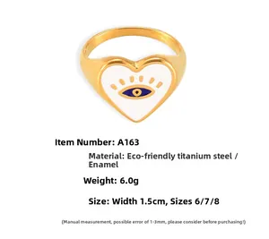 Detail of bohemian gold-plated heart ring with blue evil eye enamel finish and size specs