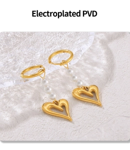 Détail de boucles d'oreilles cœur plaquées or PVD avec perles et éclat métallique