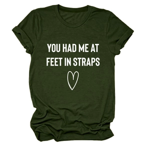 Detail eines armee-grünen Rundhals-T-Shirts mit 'YOU HAD ME AT FEET' Print und Herzlogo