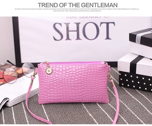 Detailed view of pink crocodile-patterned mini bag with gold hardware and strap