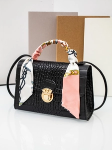 Black crocodile embossed handbag featuring gold lock detail and decorative floral silk scarf