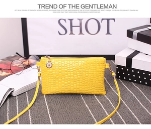 Detail view of the yellow crocodile pattern PU leather crossbody bag with a metal pendant