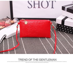 Detailed view of red crocodile embossed PU leather mini bag with golden zipper accents