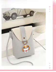 Detail of mini crossbody phone bag with cute dog pendant and gold ring buckle closure