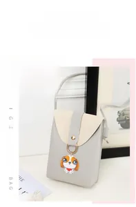 Close-up of a two-tone mini crossbody phone bag with a cute cartoon puppy pendant