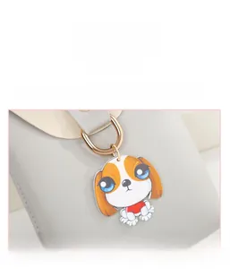 Detail of cute cartoon dog charm with blue eyes on light gray leather handbag strap