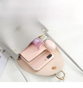 Internal capacity of mini crossbody bag showing phone, wallet, and cosmetics