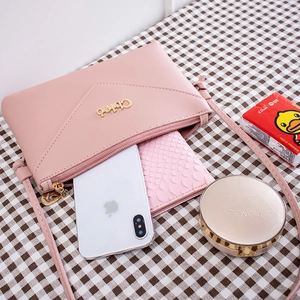 Pink envelope crossbody phone bag showing interior capacity for essentials like makeup