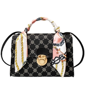 Classic black crossbody bag with geometric floral pattern and silk scarf handle detail