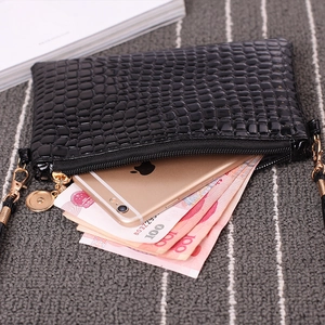 Black crocodile embossed cross-body bag showing inner capacity with golden hardware
