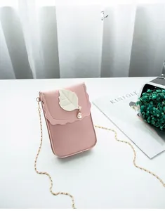 Détail du mini sac de téléphone rose avec rabat ondulé, breloque perle et chaîne dorée