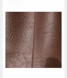 Detail of vintage dark brown faux leather with soft pleated texture and matte finish