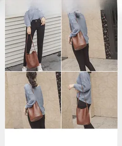 Detailed outdoor view of a brown leather bucket bag with long shoulder straps and handle
