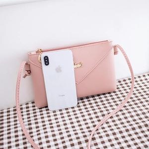 Pink lychee texture crossbody bag with V-shaped flap shown next to a smartphone